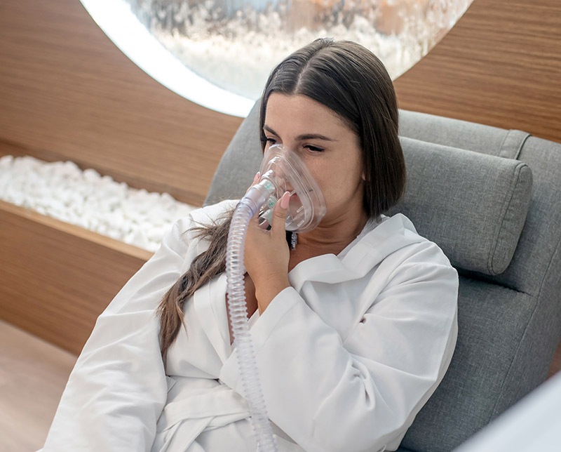Inhalation. A woman having an oxygen mask in a medical center